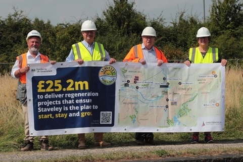 Image shows Darren Green, Triton Construction Ltd, Ivan Fomin, Cllr Tony King and Cllr Tricia Gilby on site holding a Staveley Town Deal banner