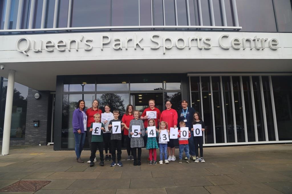 Swimming instructors, pupils and representatives from the charities outside Queen's Park Sports Centre